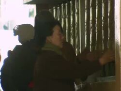 MS Women entering and praying with prayer wheels / Dharamsala, Himachal Pradesh, India Stock Footage