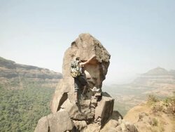 Young man climbing a cliff of mountain  Stock Footage