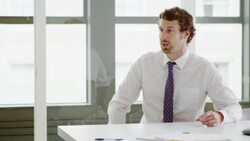 MS Smiling businessman in discussion with colleague at conference room table Stock Footage