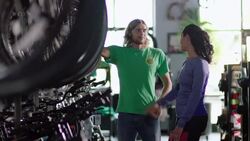 Friendly employee approaches female customer and offers assistance in bike shop Stock Footage
