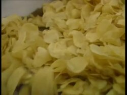CU Potato crisps falling off conveyor belt Stock Footage
