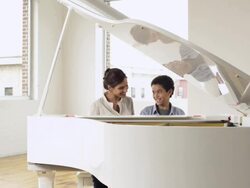 Boy and teacher at piano, zoom in Stock Footage