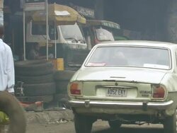 MS Street with teenagers passing with big wheels / Lagos, Nigeria Stock Footage