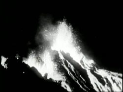 Kilauea Volcano erupts and lava sprays into the air and flows down a hill. News Clip