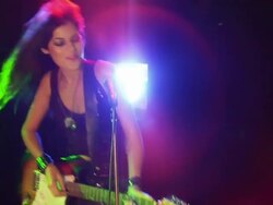 Medium shot slow motion young woman playing an electric guitar, singing, dancing about Stock Footage