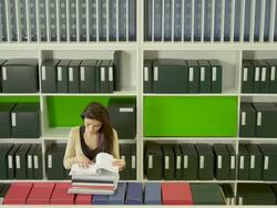 HA WS woman leafing through documents in office library Stock Footage