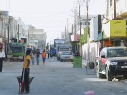 WS View of houses and parking car on street with people / Desert Town, Jordan Stock Footage