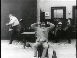 B/W 1916 2 men in pie fight (Eric Campbell + Charlie Chaplin) / angry film director in foreground / short Stock Footage