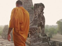 WS, PAN Buddhist monks walk along the top of an ancient temple high above the forest in Angkor Wat at sunrise / Siem Reap, Cambodia Stock Footage