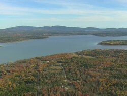 WS AERIAL View of wooded area with autumn color at bay / Maine, United States Stock Footage