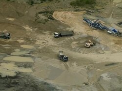 AERIAL WS ZI Trucks and bulldozers driving at quarry site near Rives / Rhone-Alpes, France Stock Footage