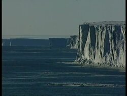 WA Ice cliffs rising out of sea, casting shadows, Antarctica Stock Footage