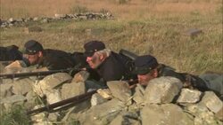 Union soldiers fire their rifles from behind a ruinous stone wall. Stock Footage