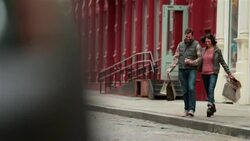Taxi drives past, happy New York couple with shopping bags hurriedly cross Soho street hand-in-hand (dolly-shot) Stock Footage