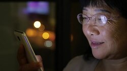 close-up of old woman using mobile phone at home Stock Footage