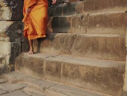 CU Buddhist monks climb down the ancient steps of a temple in Angkor Wat at sunrise / Siem Reap, Cambodia Stock Footage