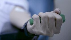 blood donor squeezes ball in his hand Stock Footage