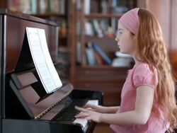 Young girl playing the piano Stock Footage