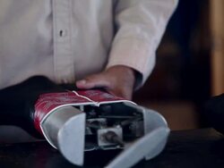CU boot maker standing at counter in workshop measuring shaft of cowboy boots on instep shaft stretcher Stock Footage