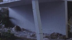 A building collapses as flood-waters surge around it. Stock Footage