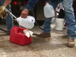 MS TD Shot of two men filling gas cans from truck as people waiting in line for fuel as Hurricane Rita approaching Texas / Texas, United States Stock Footage