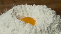 Egg falling on flour in slow motion Stock Footage