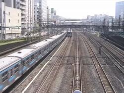 Two Japanese Commuter Trains pass Stock Footage