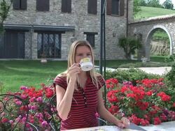 Happy woman enjoying her breakfast in the garden Stock Footage