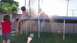 Young Girls Help Each Other Climb Onto a Trampoline Stock Footage