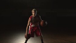 A basketball player dribbles two balls simultaneously at center court. Stock Footage