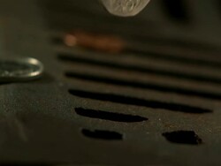 Money Down the Drain - High speed English coin, 20p with Tudor rose design, falling in to road drain, low angle 3, BCU Stock Footage