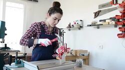 Young woman nailing wood plate in a workshop Stock Footage