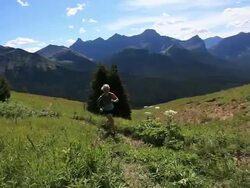 PAN of female athlete running up mountain path Stock Footage
