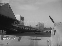 1952: INDIAN AIRCRAFT: WS Deccan Airways Douglas DC-3 (VT-AXE) being pulled out of hangar at airfield (crashed 2/19/1952 3 of 16 fatalities), two men turning, pushing propeller of smaller aircraft at airport. Instructional Video