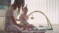 Mom Coloring Book for Adults and Playing With Her Baby. Stock Footage