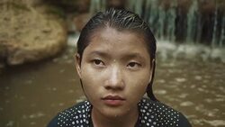 M/S SLO MO Myanmar teenage girl taking a bath in a waterfall in the forest Stock Footage