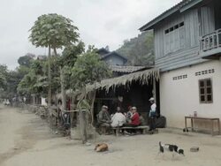 WS people sitting outside house / Xam Neua, Laos Stock Footage