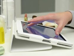 Dolly,L to R Female using tablet computerat make-up table Stock Footage