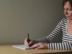 Woman writing notes in textbook Stock Footage