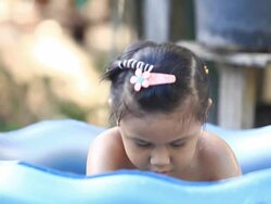 asia girl  playing in a paddling pool Stock Footage