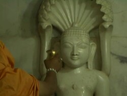 Tilt down priest bathing lord parshavnath jain temple champaner gujarat Stock Footage