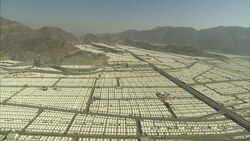 An aerial view reviews a vast area of rows of white tents  in Saudi Arabia. Stock Footage