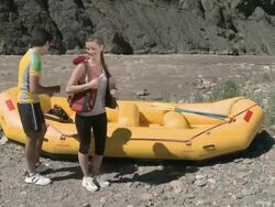 Man and woman putting on lifejackets ready for rafting  Stock Footage