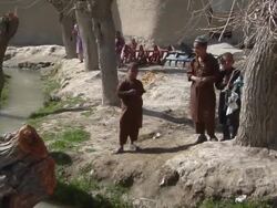 WS PAN ZO Soldiers walking in row by field/ Musa Qala, Helmand Province, Afghanistan. Stock Footage