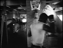 B/W 1956 Floyd Patterson hitting punching bag in training in gym / newsreel Stock Footage