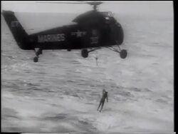 B/W 1961 AERIAL astronaut, Gus Grissom, being lifted from ocean to helicopter after splashdown Stock Footage