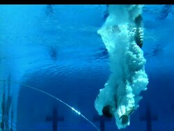Low Angle, Locked Down - Underwater view of a man diving into a pool / USA Stock Footage