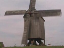 Man fighting against old wood Windmill - like Don Quixote Stock Footage