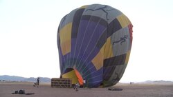 A burner blows flames into a hot air balloon in the desert. Stock Footage