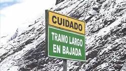A sign cautions drivers along a high, snowy road in the Peruvian mountains. Stock Footage